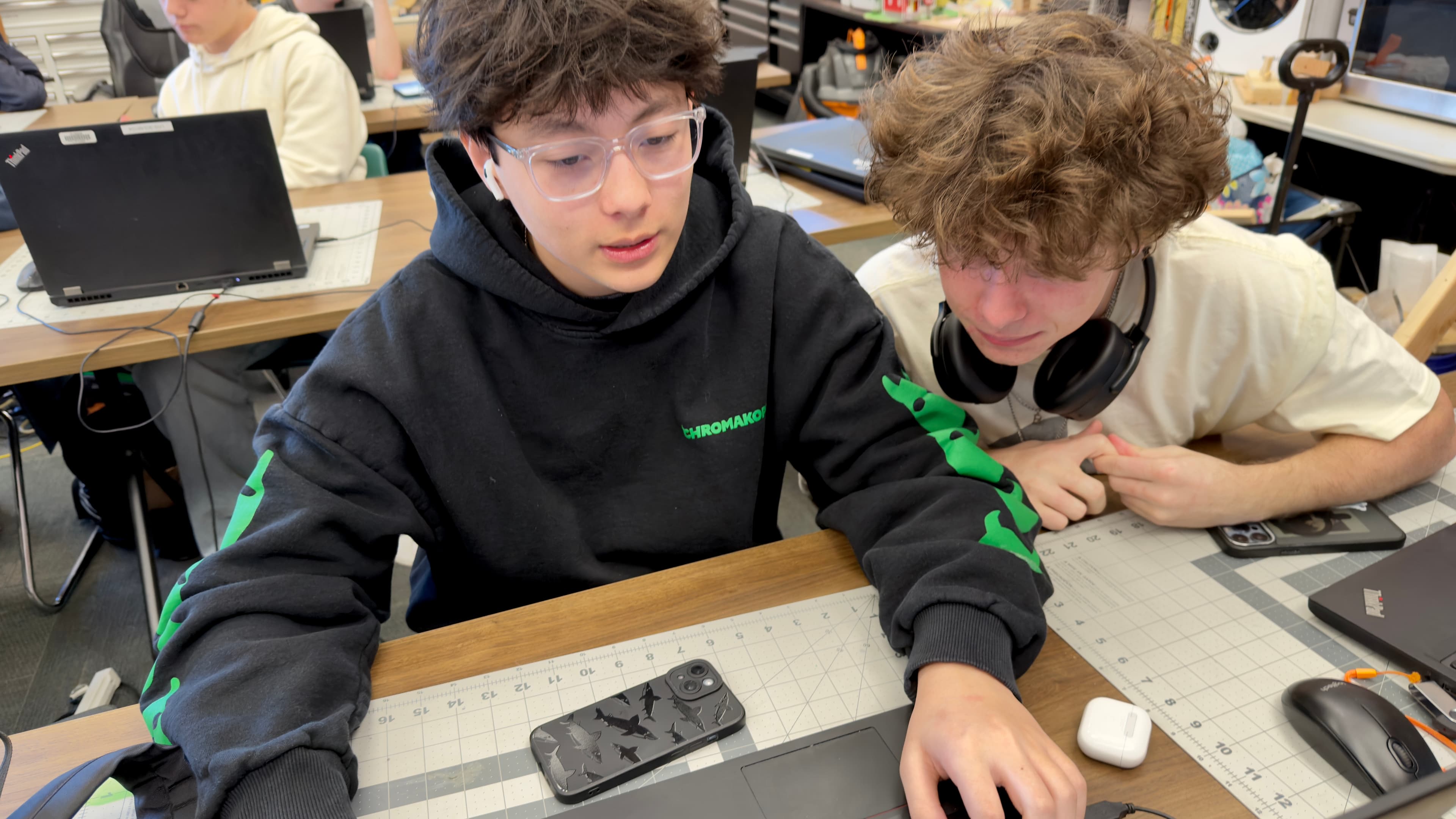 Two GEA students working together at a laptop in the engineering classroom